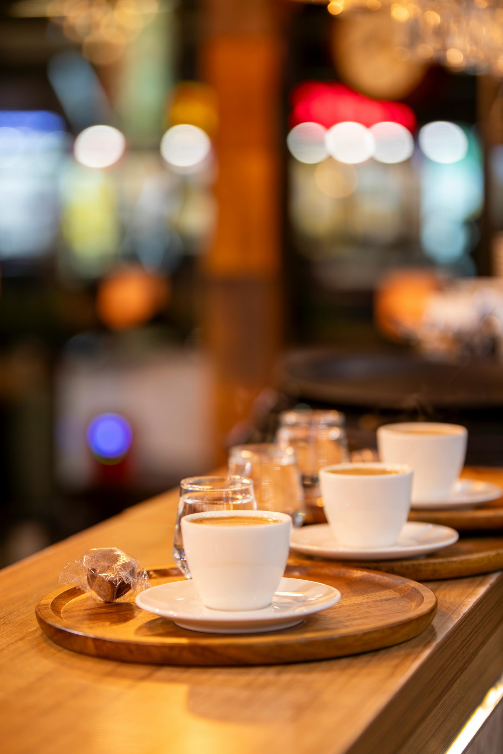 Warm and inviting cafe scene with steaming coffee cups on wooden trays.